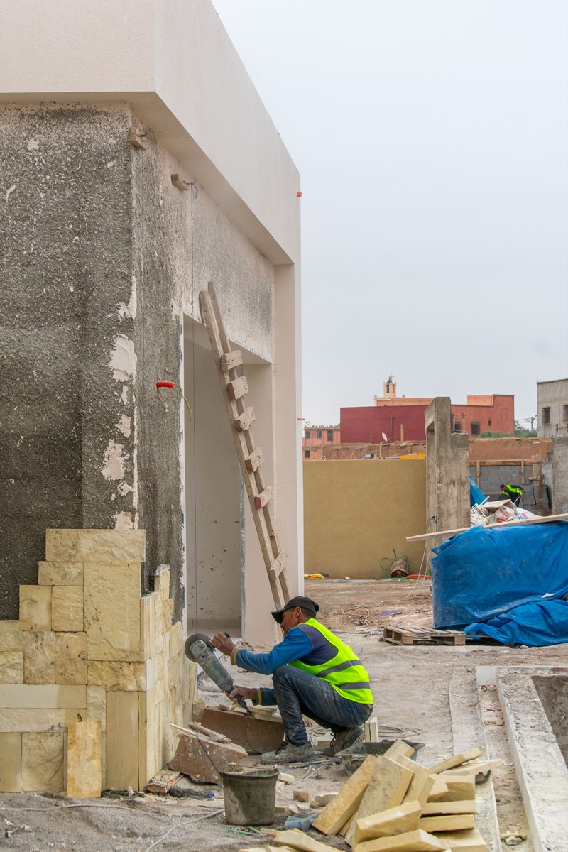 Travail sur le revêtement extérieur d’une villa en chantier.